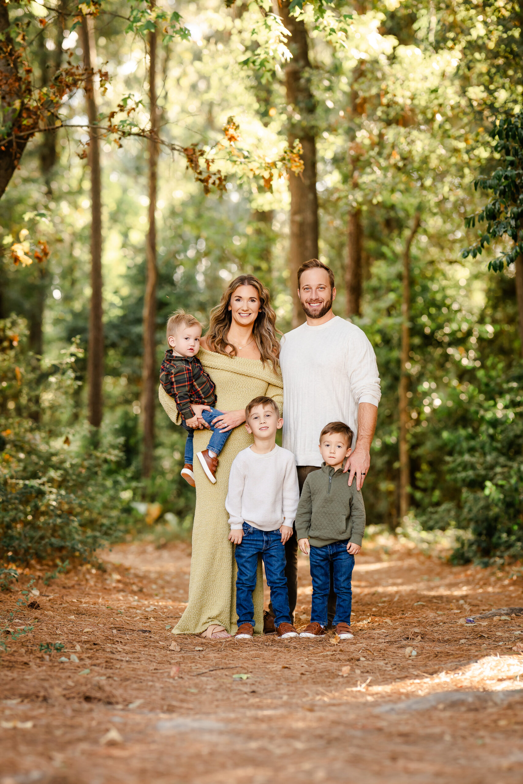 Picture of a family standing in a forest during their Fall family photo session near Houston, Texas.