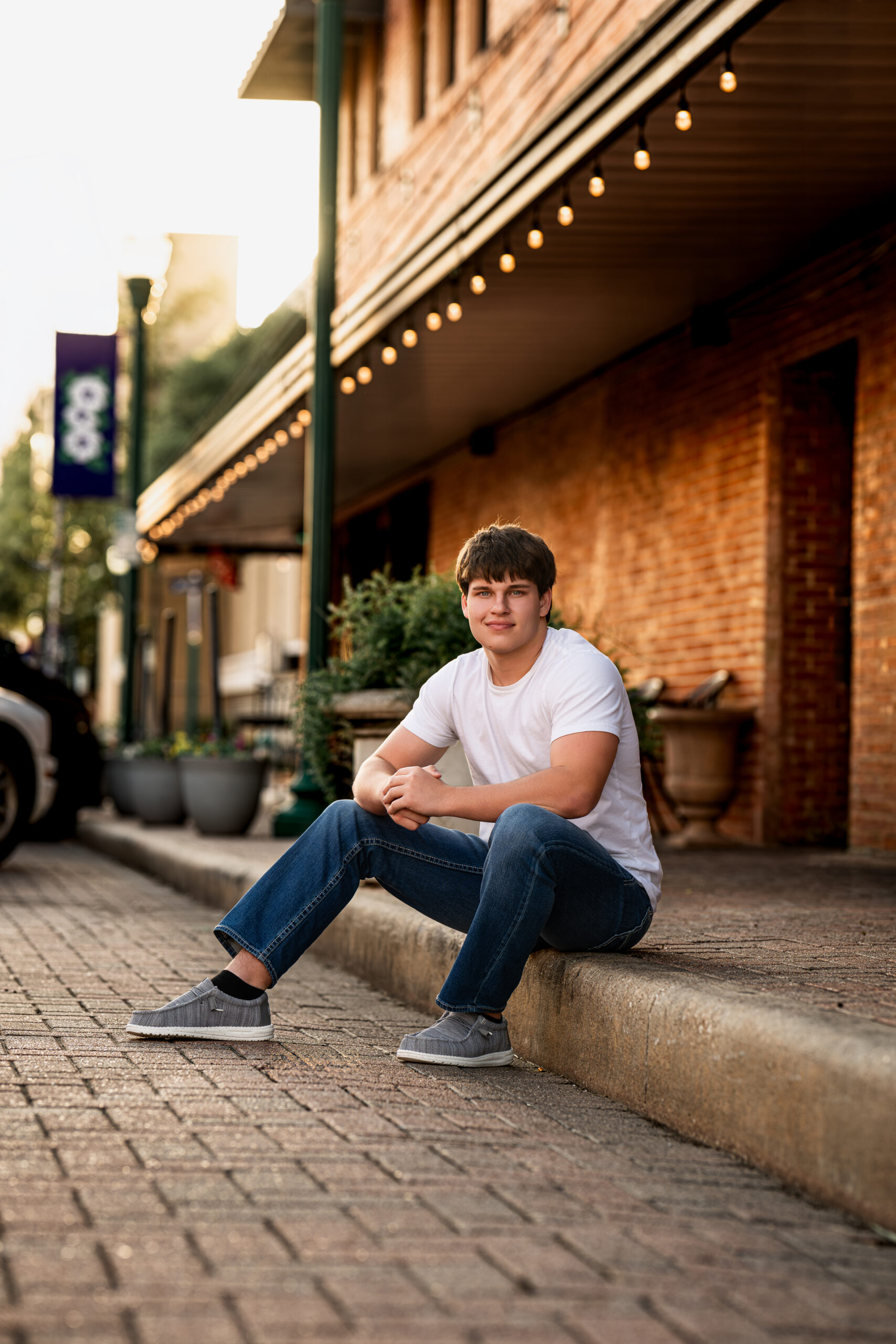 Picture of a high school senior sitting on a curb near Spring, Texas.